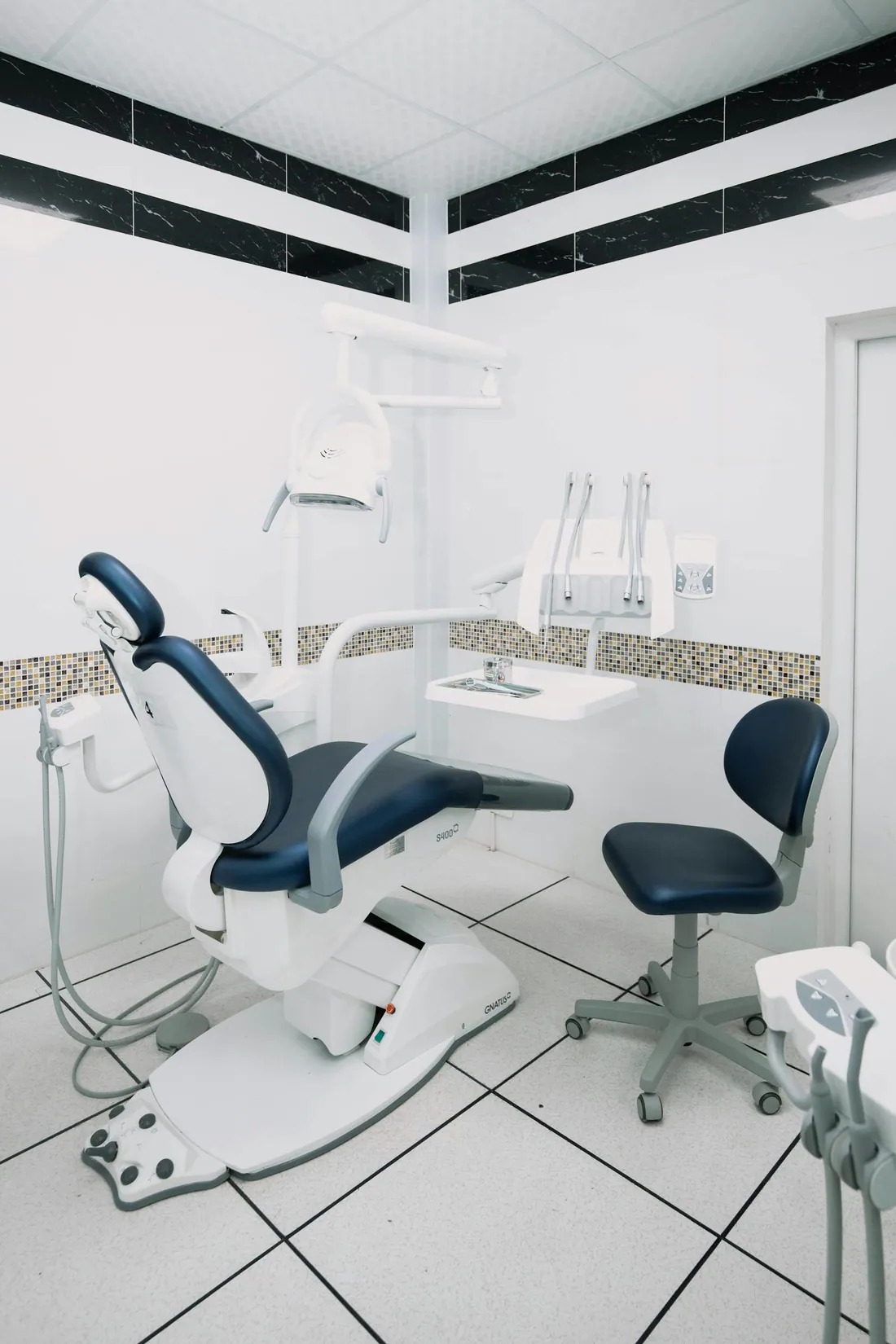 A modern dental clinic treatment room with a chair and equipment